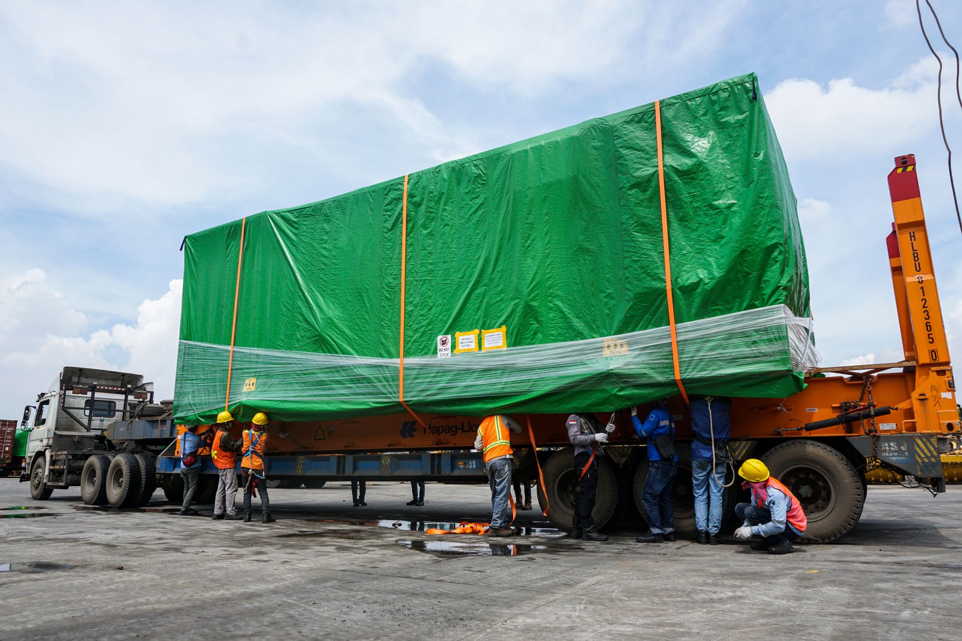 Workers loading cartons of frozen meat into a refrigerated shipping container