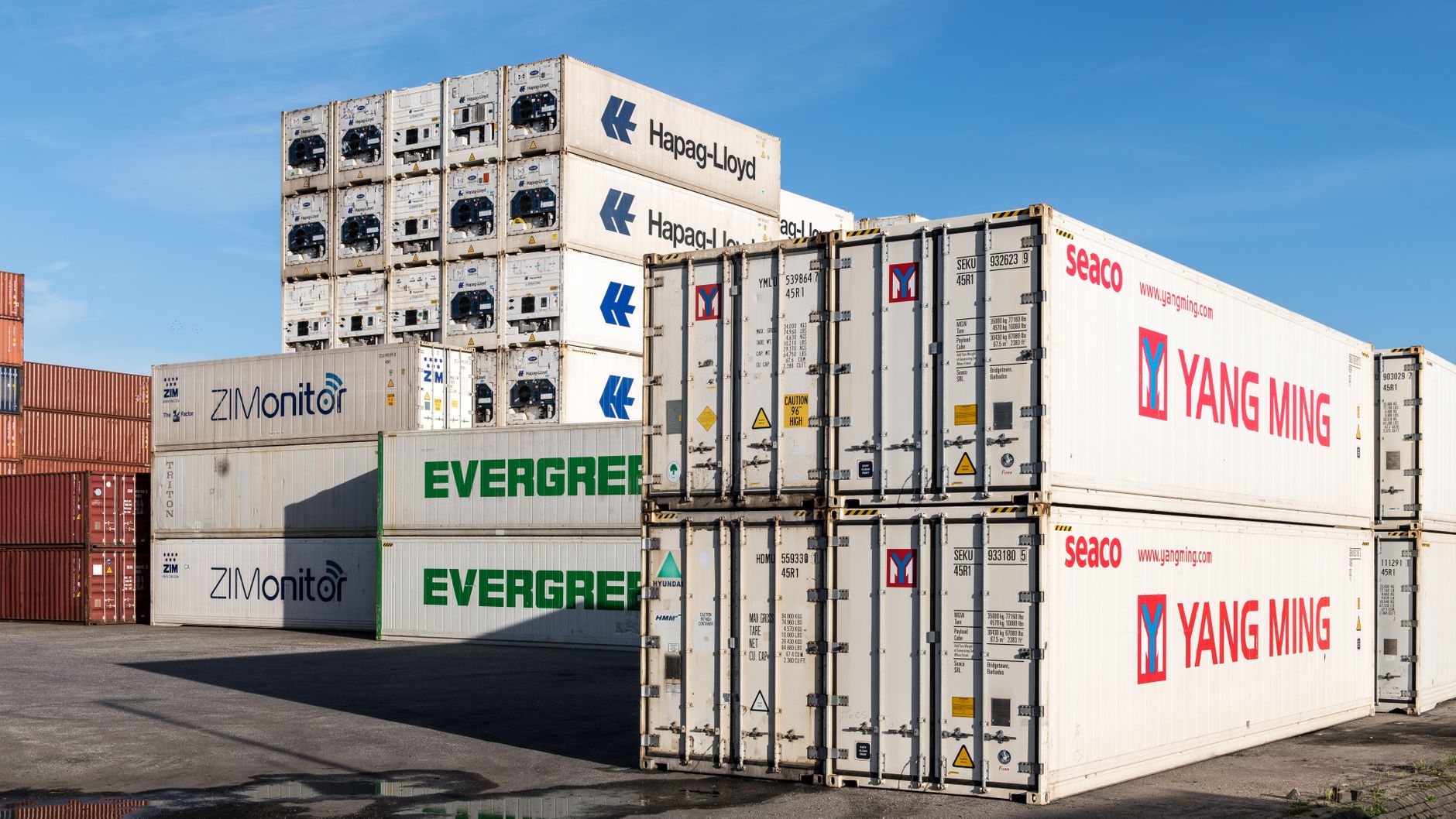 Refrigerated shipping containers stacked at a port terminal awaiting collection